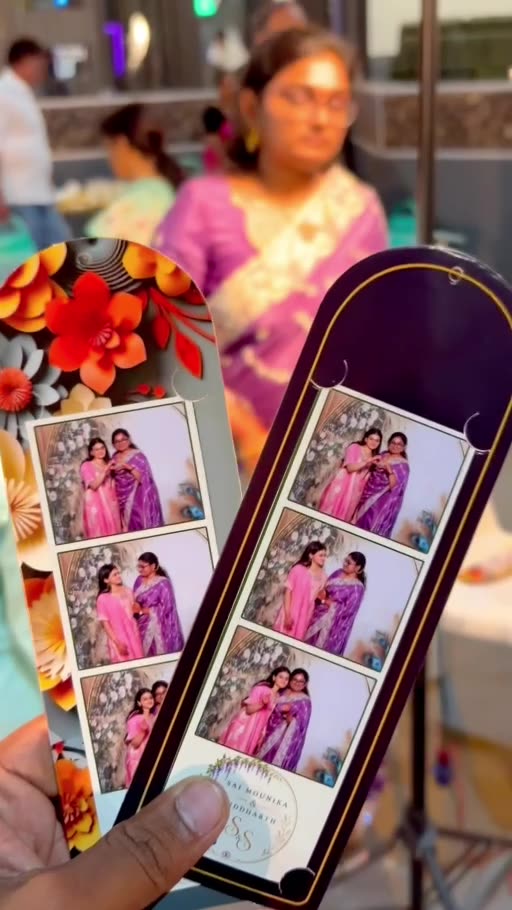 Two printed OctoSnap photo strips held in front of guests at an event